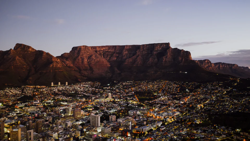 Table Mountain above Cape Town as the city lights come on at dusk